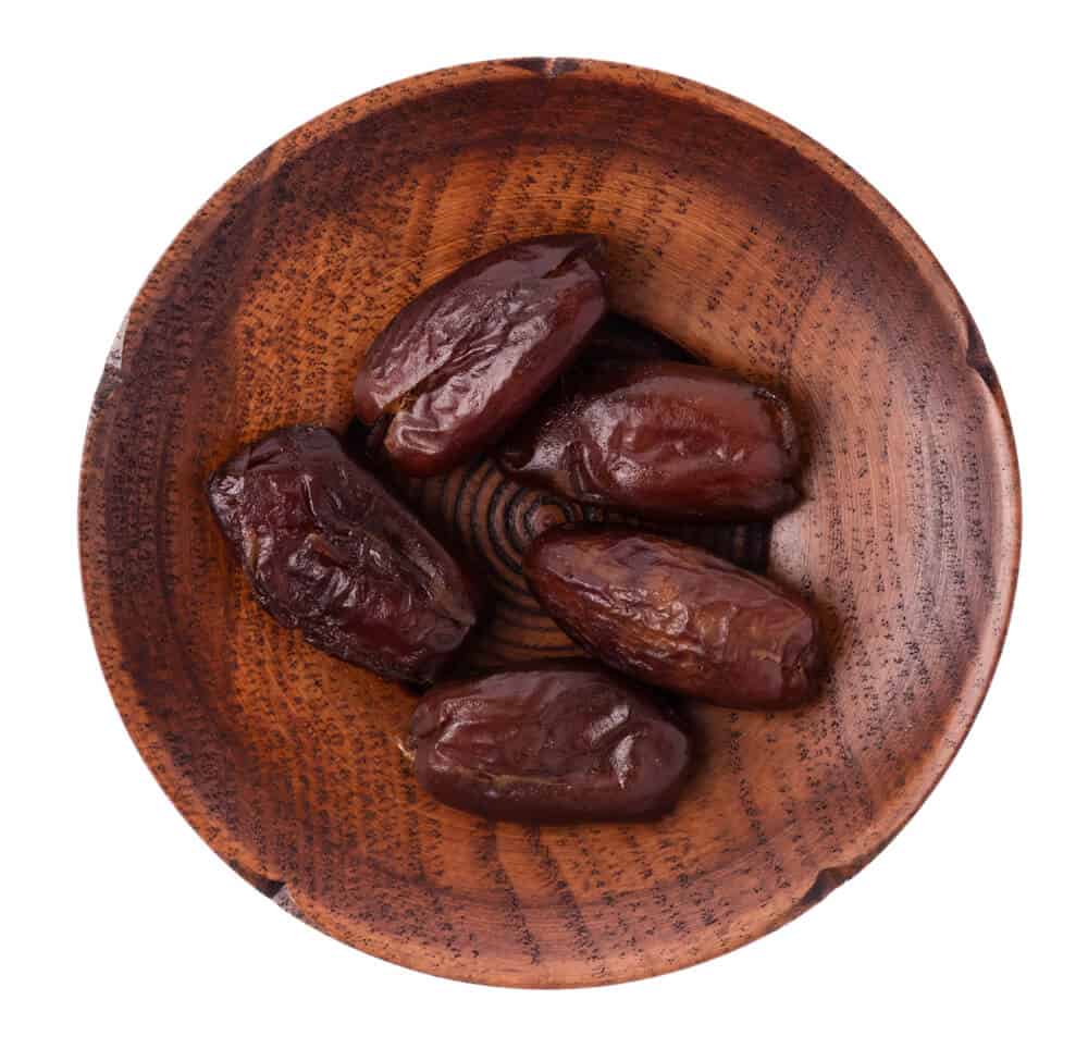 Five pieces of Halawai dates served in a wooden plate.