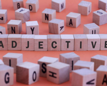 The word "adjective" formed using scrabble pieces.