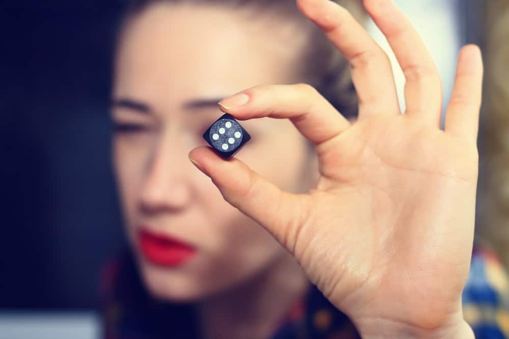 A lady is holding a dice for a backgammon game.