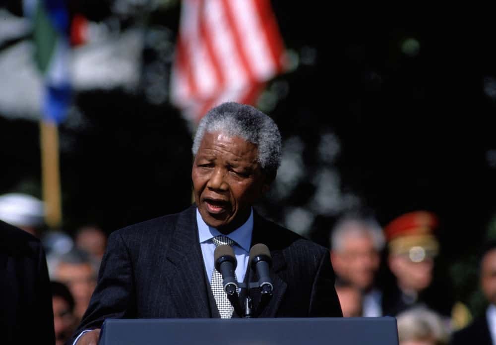 Nelson Mandela is a delivering a speech in front of a crowd. in Washington DC.