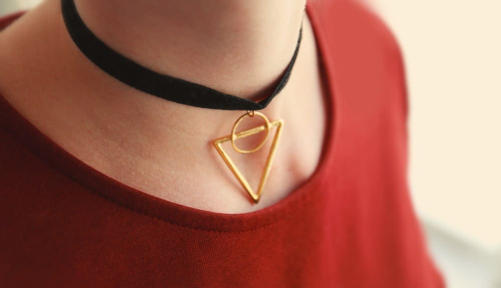 A woman wearing a choker with gold triangle.
