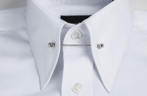Closeup of a white shirt with pin tie.