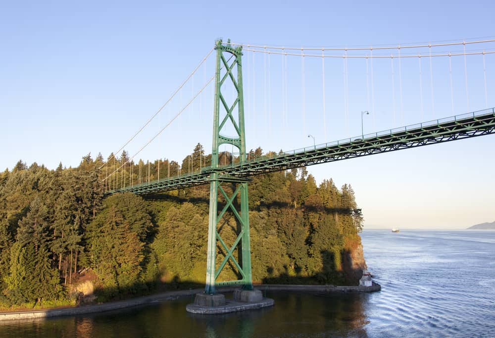 Lions Gate Bridge jutting out from Stanley Park above the Seawall