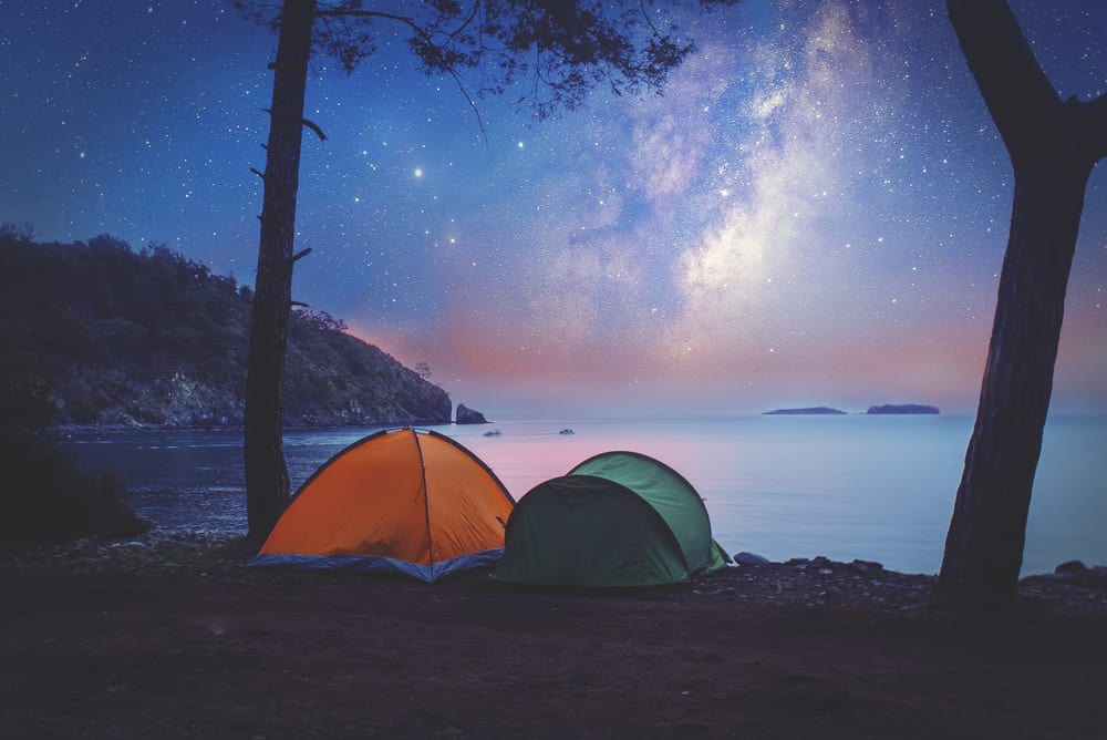 Tent camping on shore at night