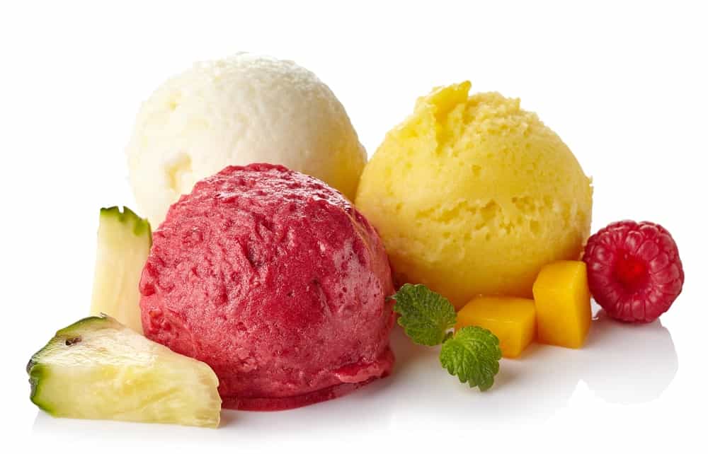Raspberry, mango, and coconut ice cream sorbet surrounded by fruits.