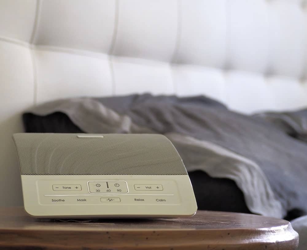 White noise machine on the bedside table.