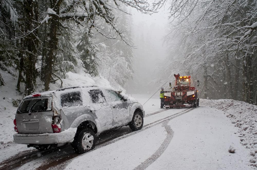 A vehicle being towed after a storm accident in the road.