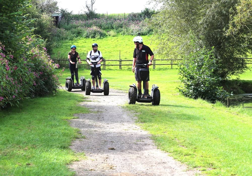 Three people riding on segway devices.