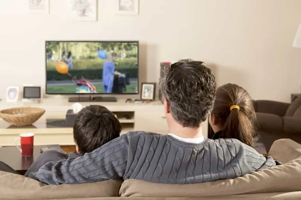 Back view of a family watching television