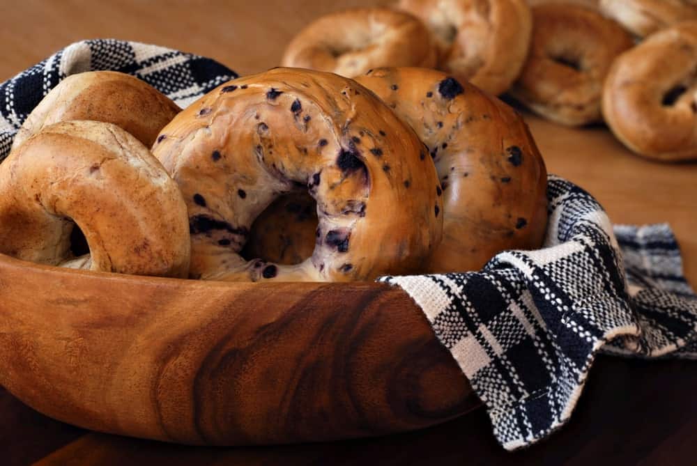 A half-cut bagel on a plate with a knife