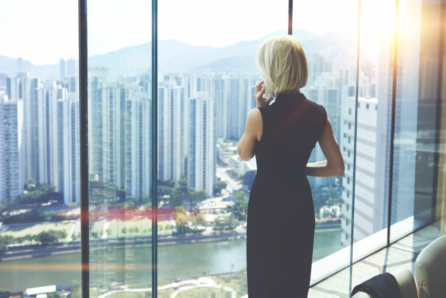 Woman CEO in skyscraper office with killer views