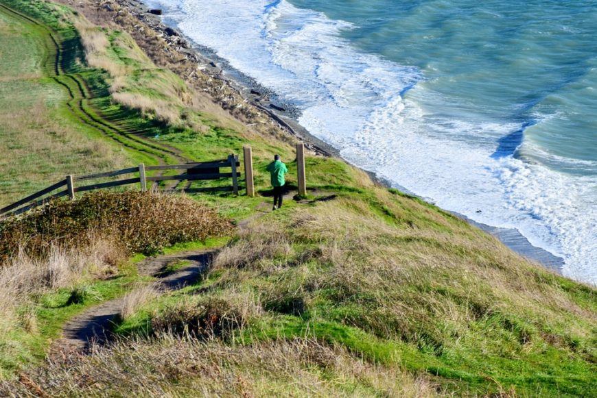 A man passing a hiking trail in Whidbey Island, WA.