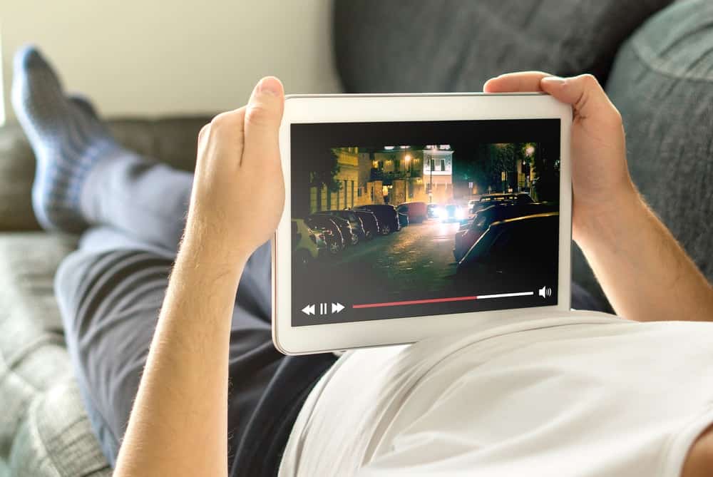 A man watching a streamed movie on his tablet.