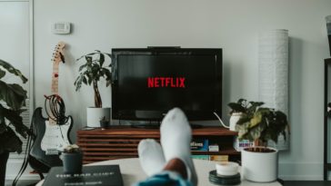 A person relaxing while watching Netflix on the TV.