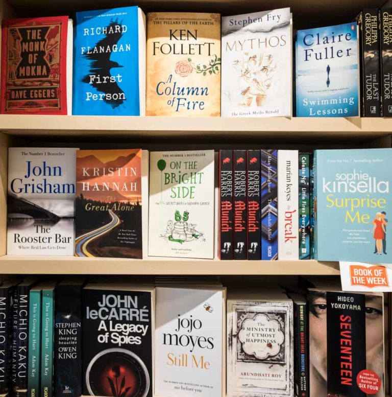 A bookshelf display in a bookstore featuring various authors including Kristin Hannah.