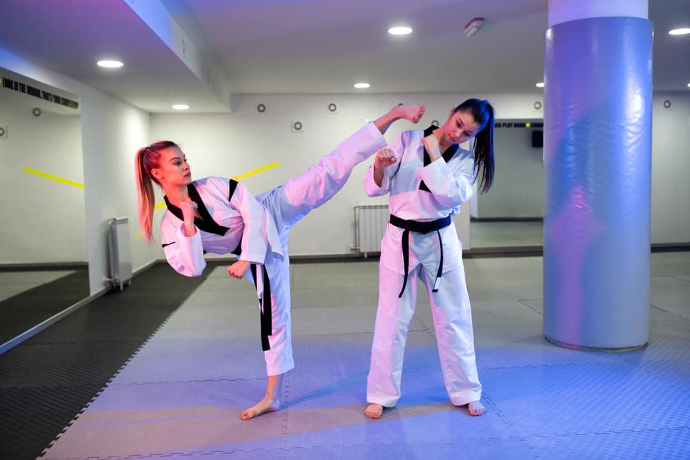 Two martial artists training in the gym.