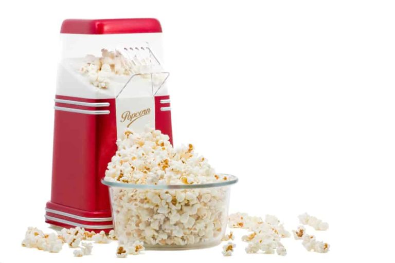 A popcorn maker and a bowl of popcorn.