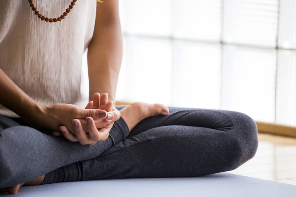 Woman practicing meditation indoors.