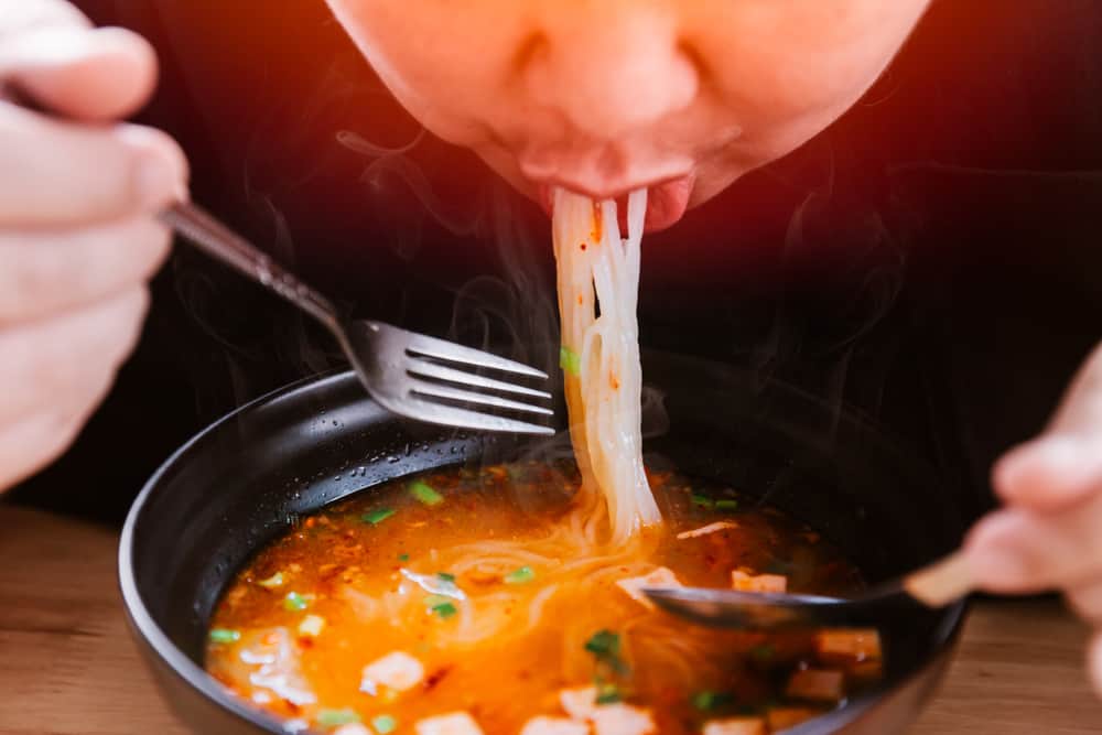 Man eating hot and spicy noodles.