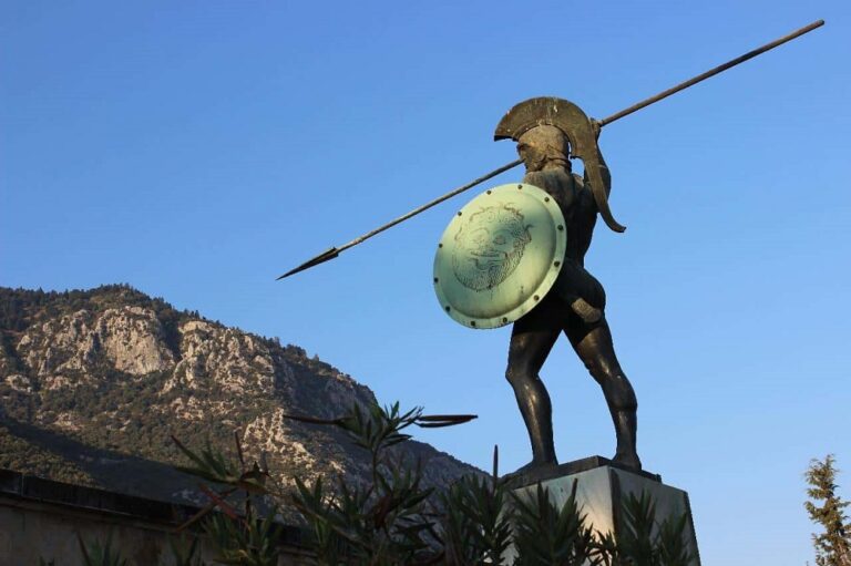 THis is a close look at a stone statue of a Spartan warrior with a spear.