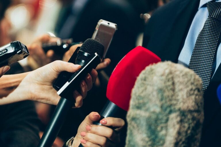 A photo of media interviewing a businessman.