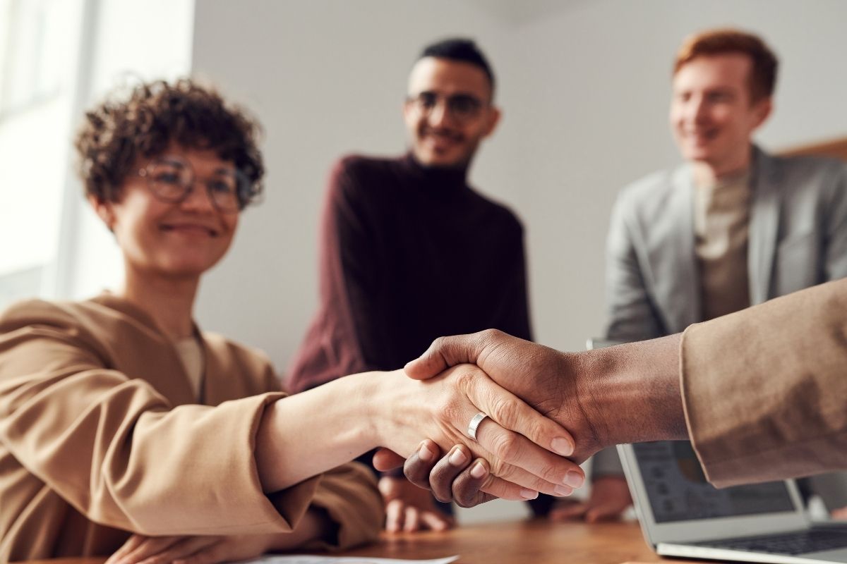 A photo of a woman shaking hands with a man.