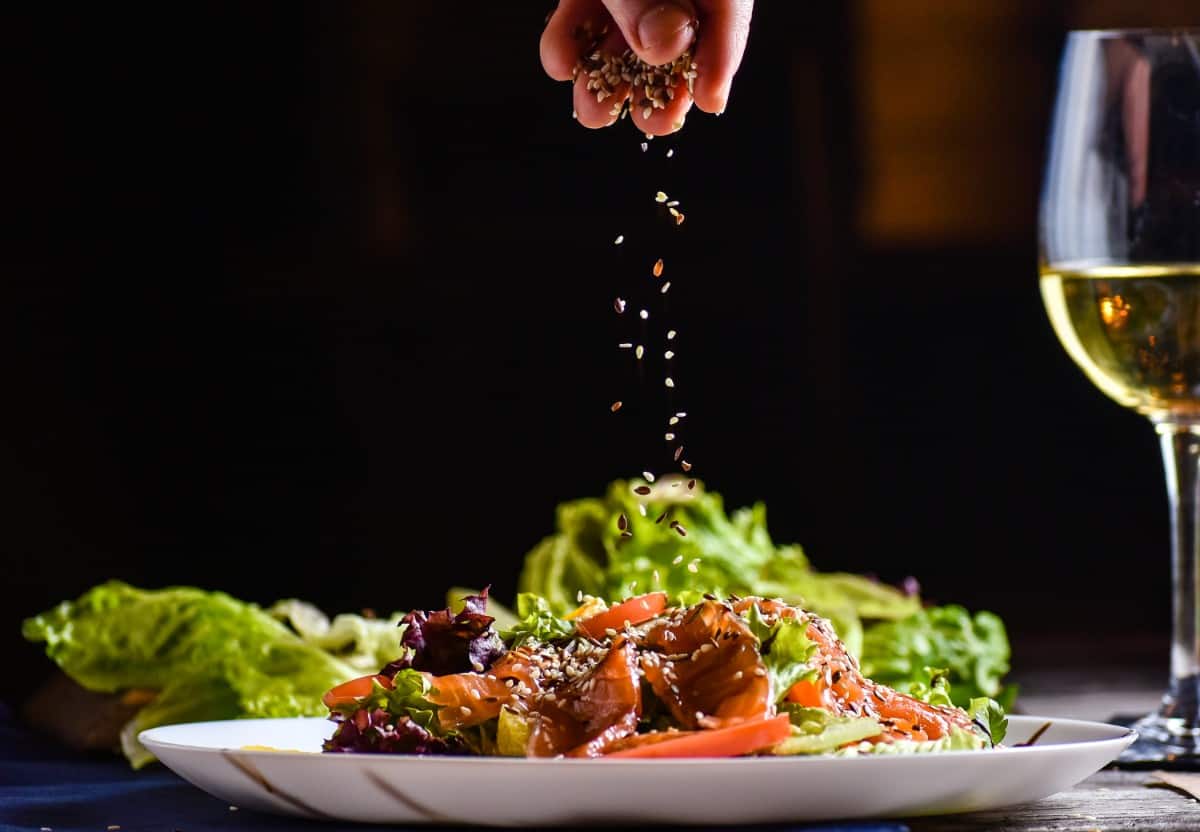 Culinary artisan garnishing salad.