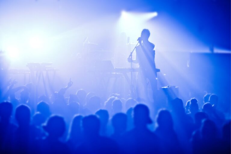 A photo of rock band concert with large crowd.