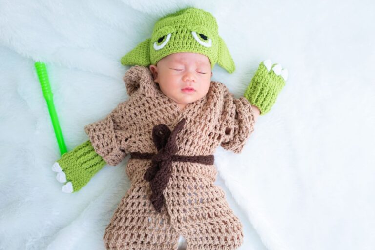 A cute newborn baby sleeping with a grogu costume.