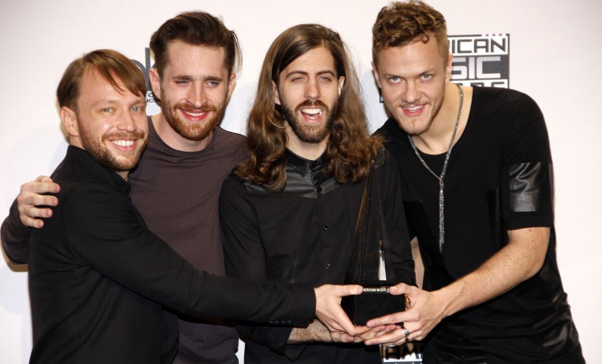 A group photo of imagine dragons band receiving a award.