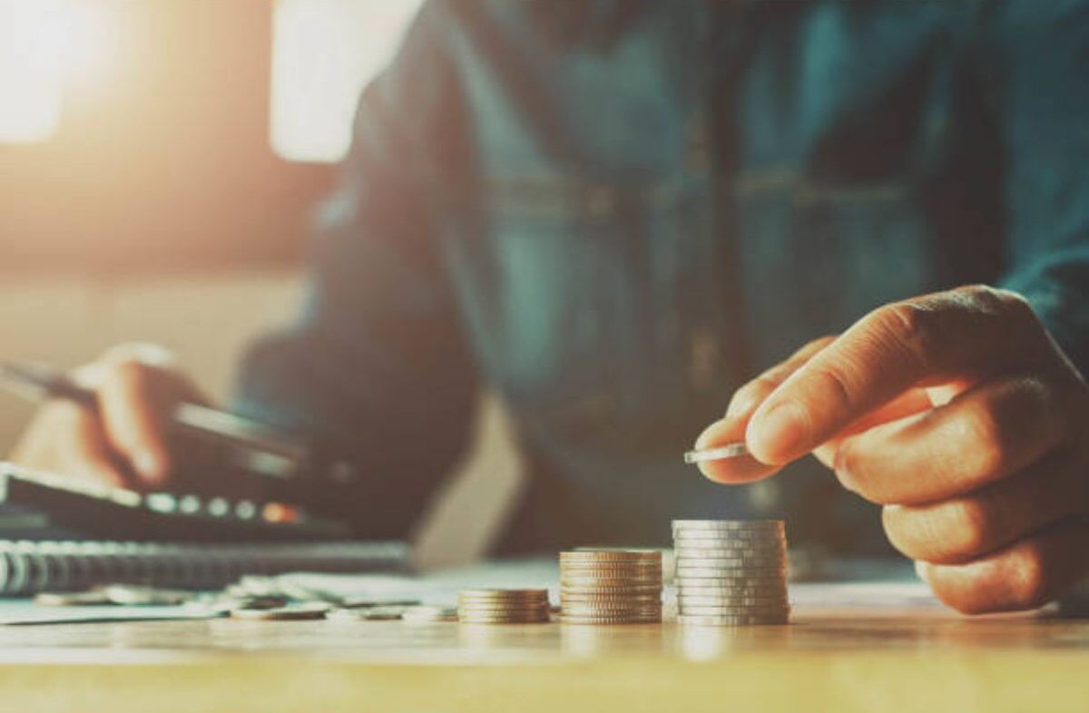 A man saving money putting coins stack.