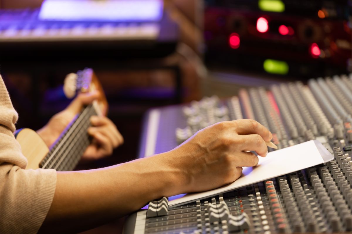 Man writing a song at his music recording studio.