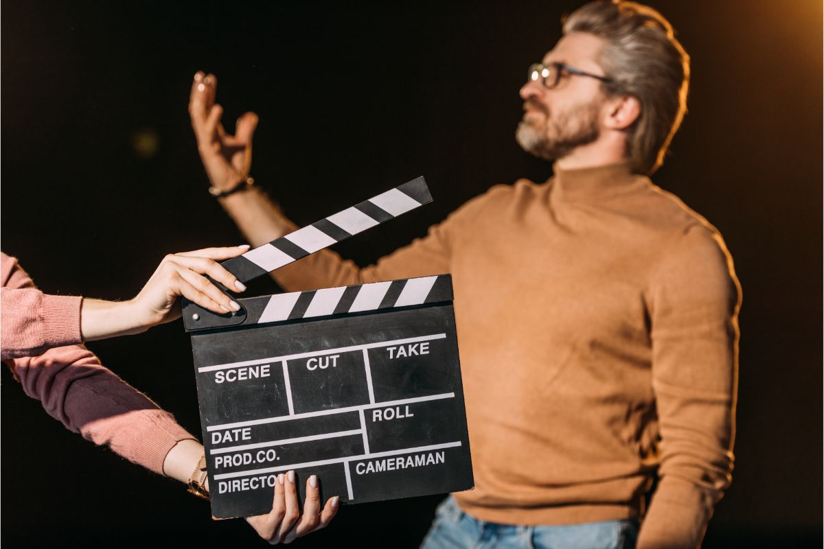 A focus of mature actor performing role with clapboard in front.